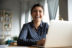 rentredi referral program hero image of smiling woman looking over laptop at camera