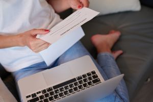 hero image for free printable eviction notice: Female sitting on the couch and holding note to leave premises in her hands