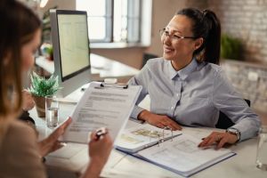 lease guarantor hero image: real estate agent handing lease agreement to new tenant