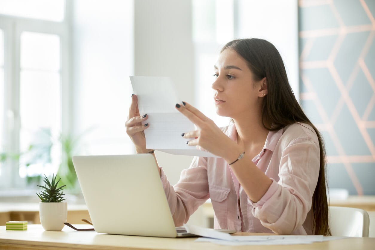 Free Landlord Reference Letter Template: Woman holding a piece of paper and reading its contents