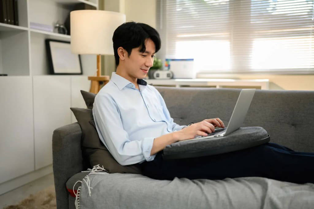 property management app for landlords used on a laptop by a man relaxing on a sofa