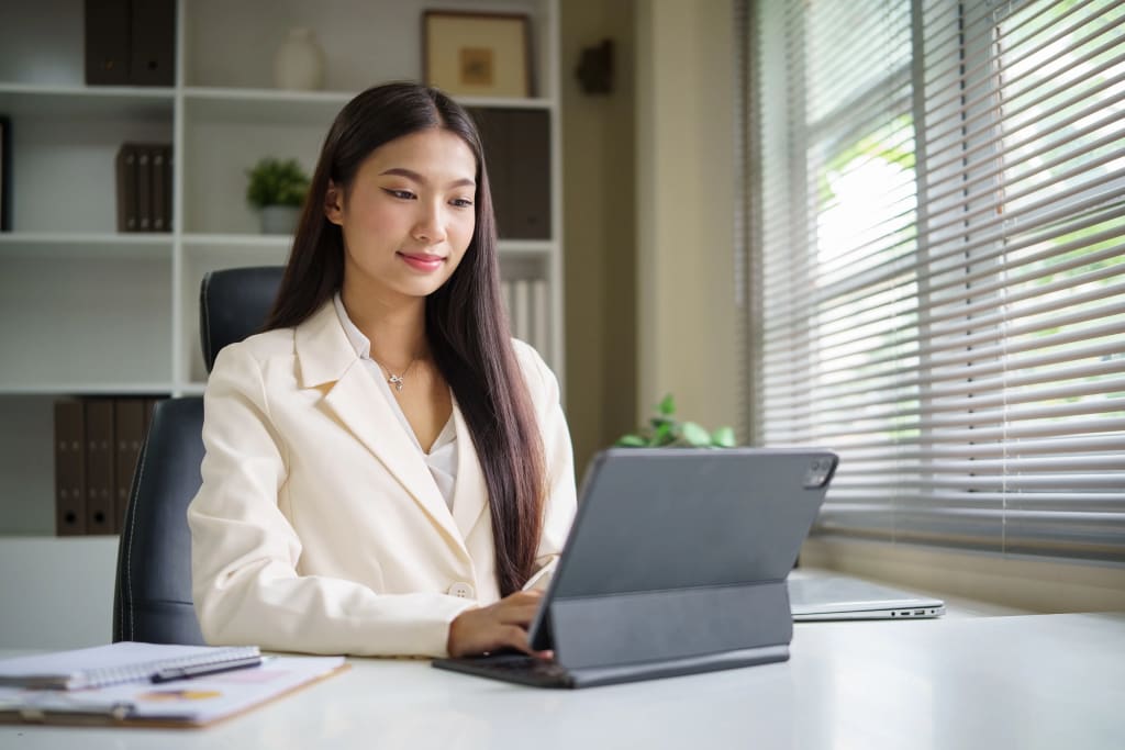 Best software for landlords used by professional woman managing properties on tablet in modern office.