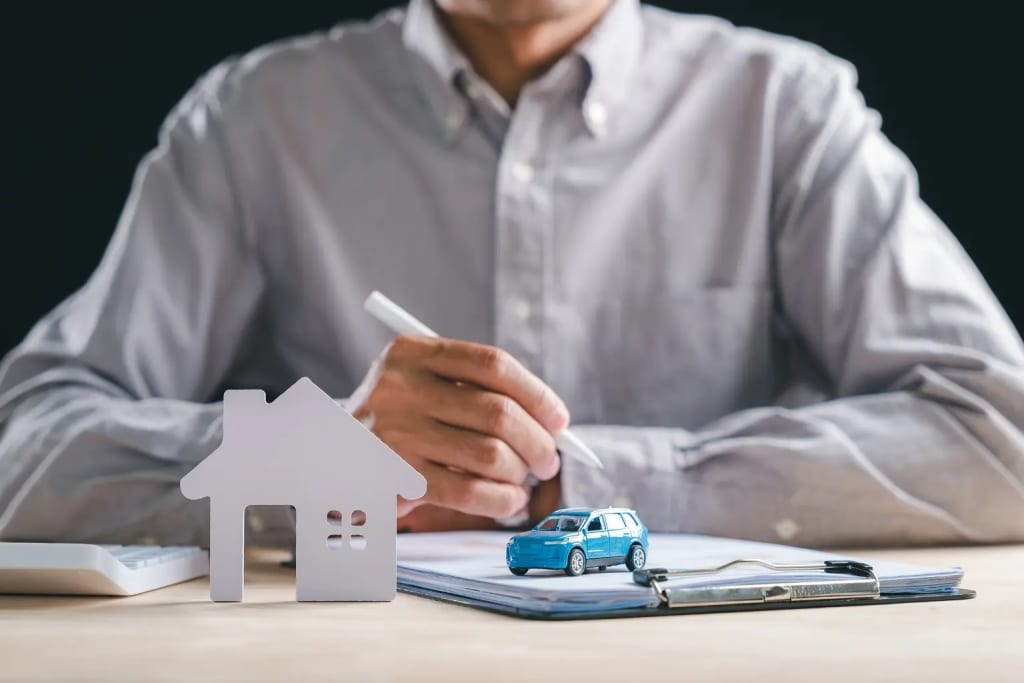 Landlord mileage tracking and asset management illustrated by a man signing documents beside a miniature house and toy car on a desk