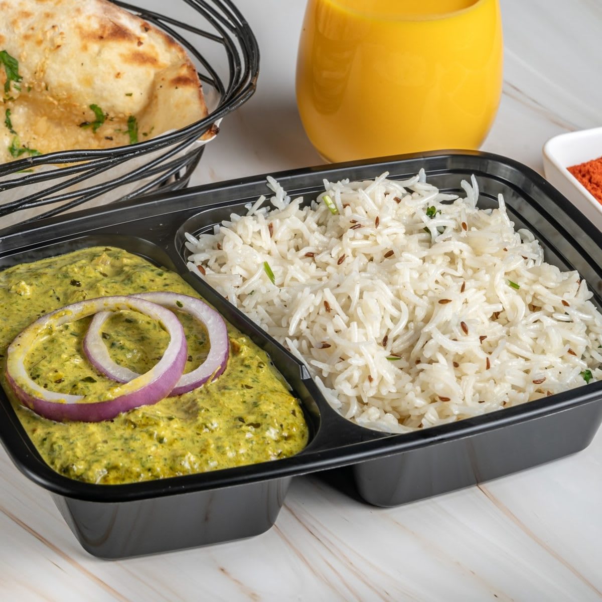 Indian meal with curry, rice, naan, and mango lassi
