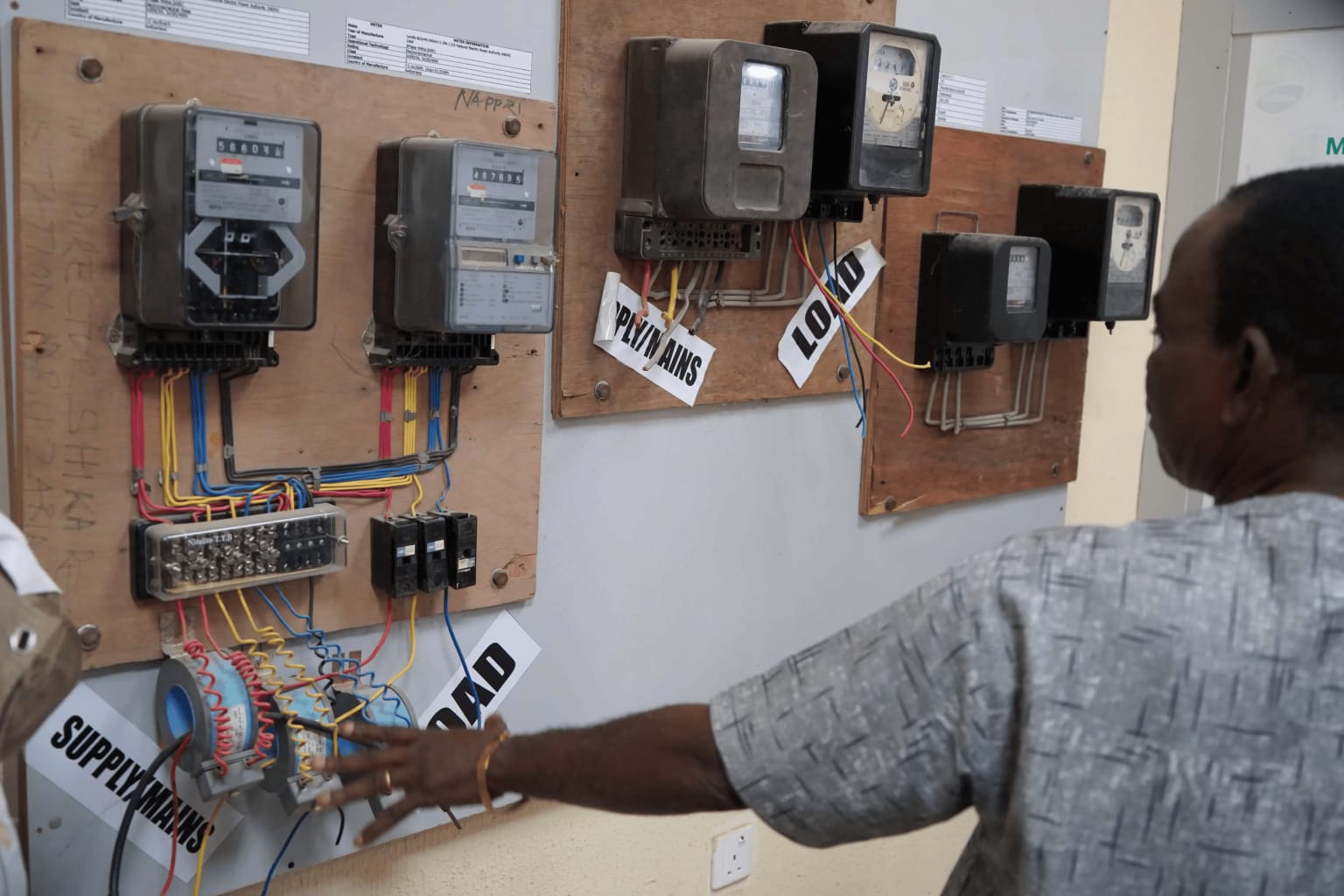An engineer inspecting a bank of electricity meters