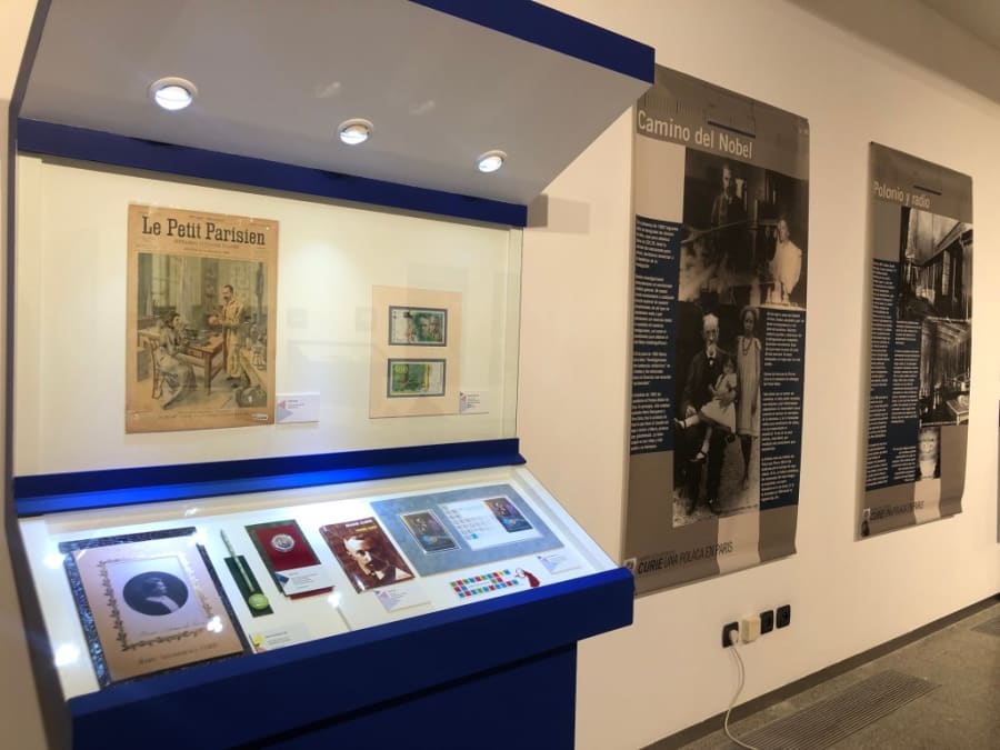 Exhibición de objetos y paneles informativos sobre la vida y obra de Marie Sklodowska-Curie, incluyendo artículos de la revista