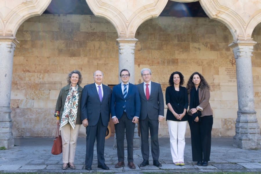 Grupo de personas posando frente a un fondo arquitectónico en un espacio al aire libre, asociado con la Universidad de Salamanca.