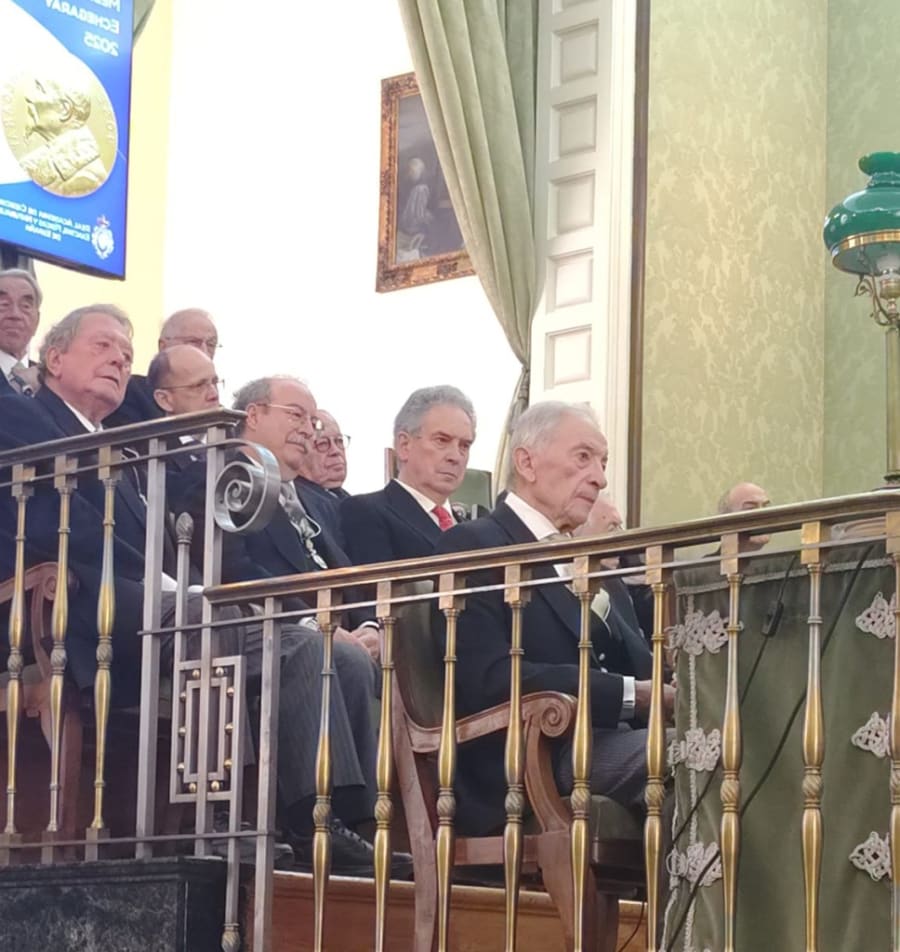 Ceremonia de entrega de la Medalla Echegaray, con un grupo de académicos sentados en el escenario, observando con atención.