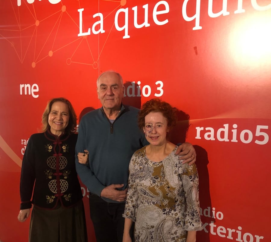 Tres personas posando frente a un fondo rojo con el logo de Radio5, sonriendo y compartiendo un momento juntos.