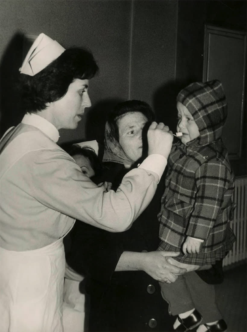 Primer día de administración de la primera dosis de la
vacuna oral Sabin contra la poliomielitis en Madrid. Fecha: 8 de
diciembre de 1963. Ministerio de Cultura y Deporte. Archivo General
de la Administración. Fondo Medios de Comunicación Social del
Estado, IDD (03)082.000, caja F/01494, sobre 32.