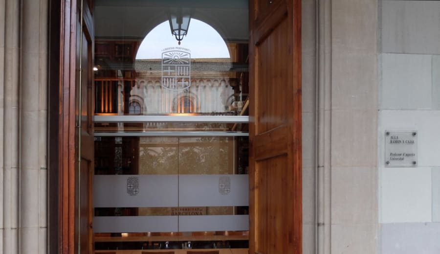 Entrada al Aula Ramón y Cajal en la Universidad de Barcelona, con detalles arquitectónicos y una placa conmemorativa.