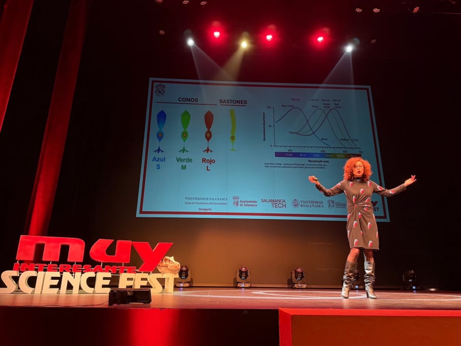 Una presentadora habla sobre la visión animal en el MUY Science Fest 2025, con gráficos sobre conos y bastones en la parte superior de la pantalla.