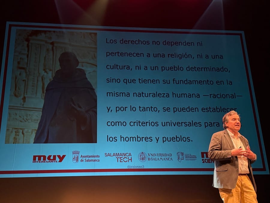 Un ponente presenta en el Teatro Liceo de Salamanca durante el MUY Science Fest 2025, con un fondo que muestra un texto sobre derechos humanos y una imagen de una figura histórica.