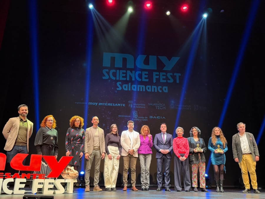 Grupo de ponentes y organizadores posando en el escenario durante el MUY Science Fest en Salamanca, con el logotipo del evento y una decoración temática.