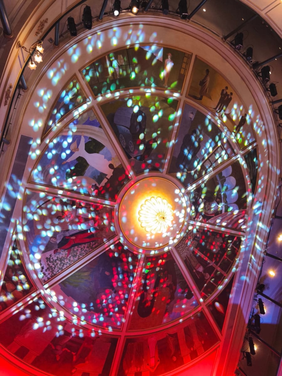 Vista aérea del techo del Teatro Liceo en Salamanca, con luces de colores proyectadas sobre acabados decorativos y murales que evocan la historia y cultura del lugar.