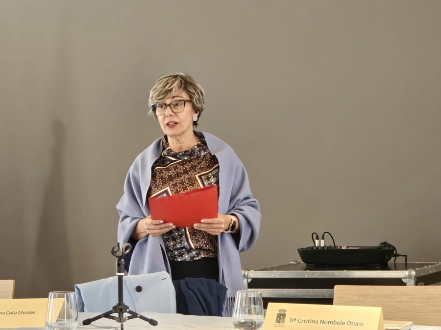 La Dra. Ana Coto Montes habla en un evento en el Museo de la Mina de Arnao, sosteniendo un documento y vestida con un chal azul.