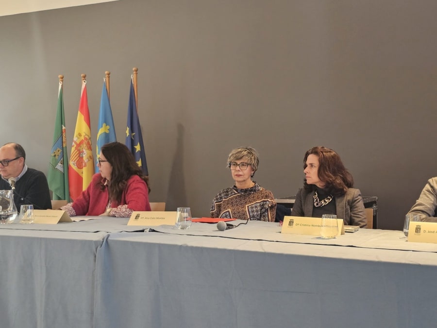 Mesa redonda con varios ponentes en el Museo de la Mina de Arnao, durante un evento sobre la figura de Santiago Ramón y Cajal, con banderas visibles en el fondo.