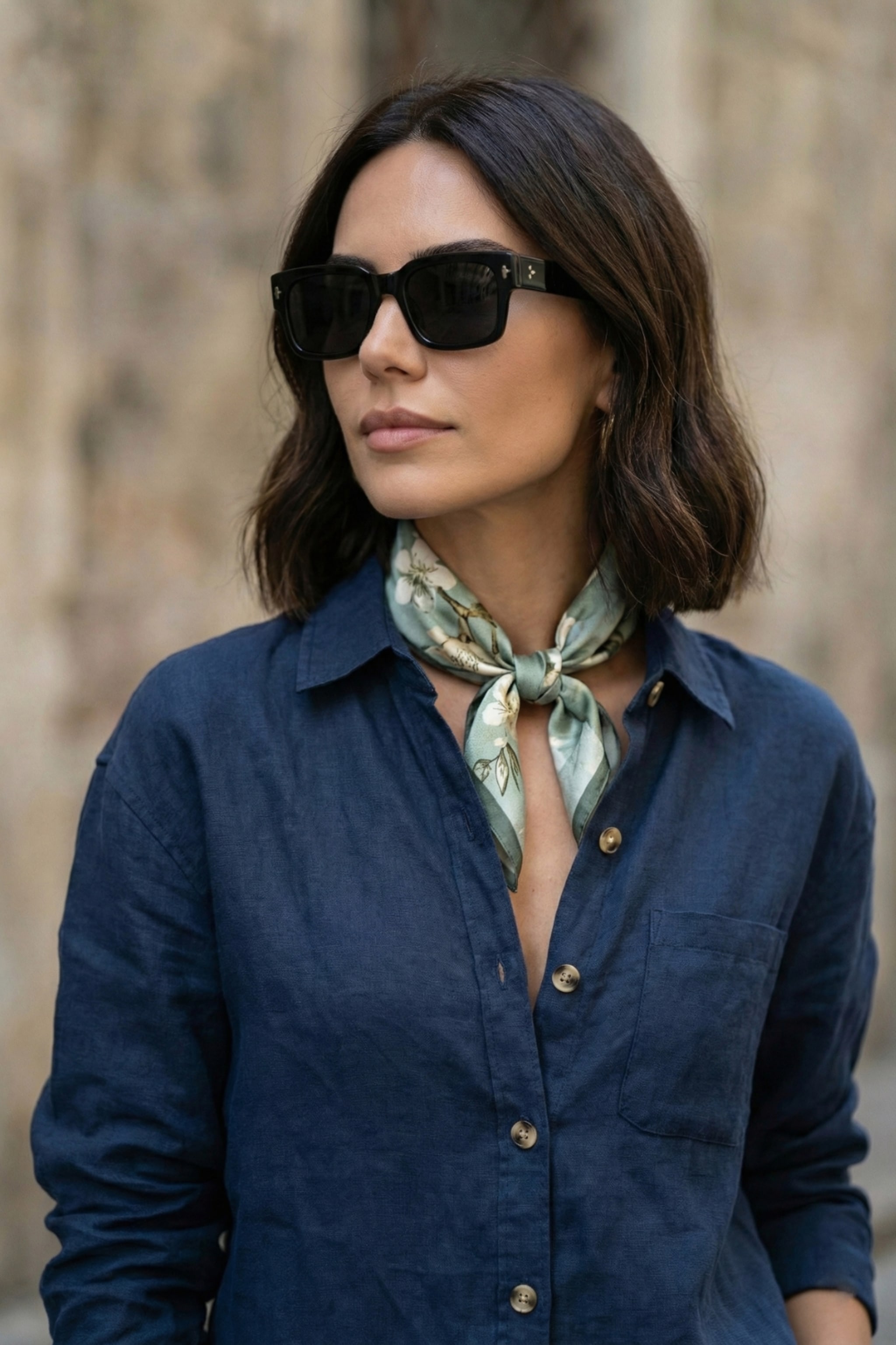 Close up of a woman sitting on rocks by the sea, next to a close up of a sage silk scarf tied around her neck. Right