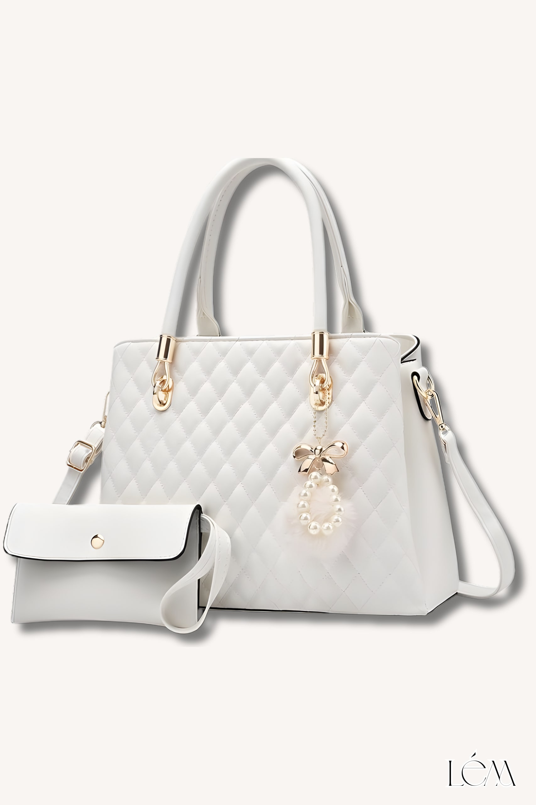 Close-up of quilted white handbag with gold hardware and charm detail