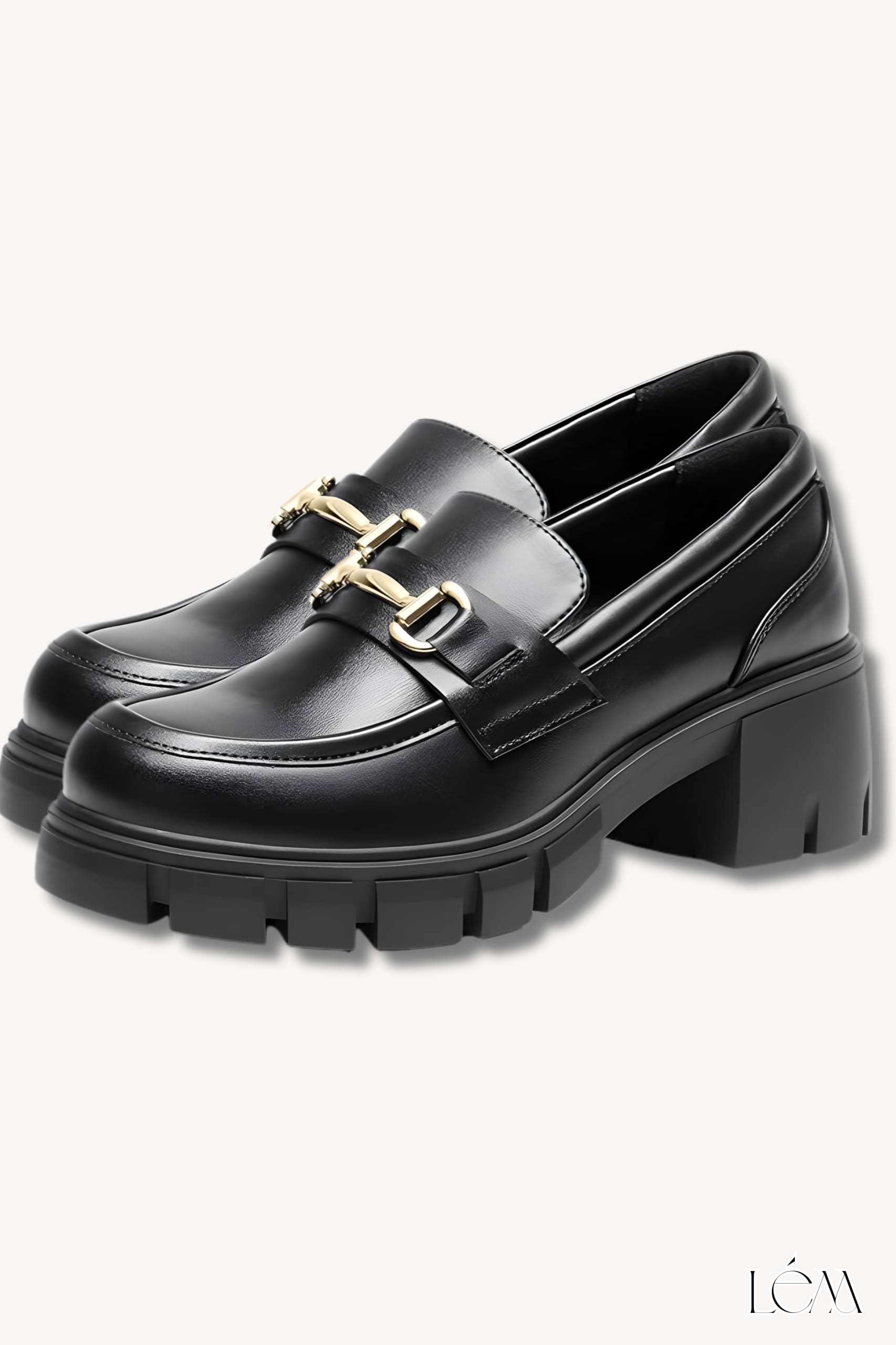 Close-up of black platform loafers with gold hardware detail