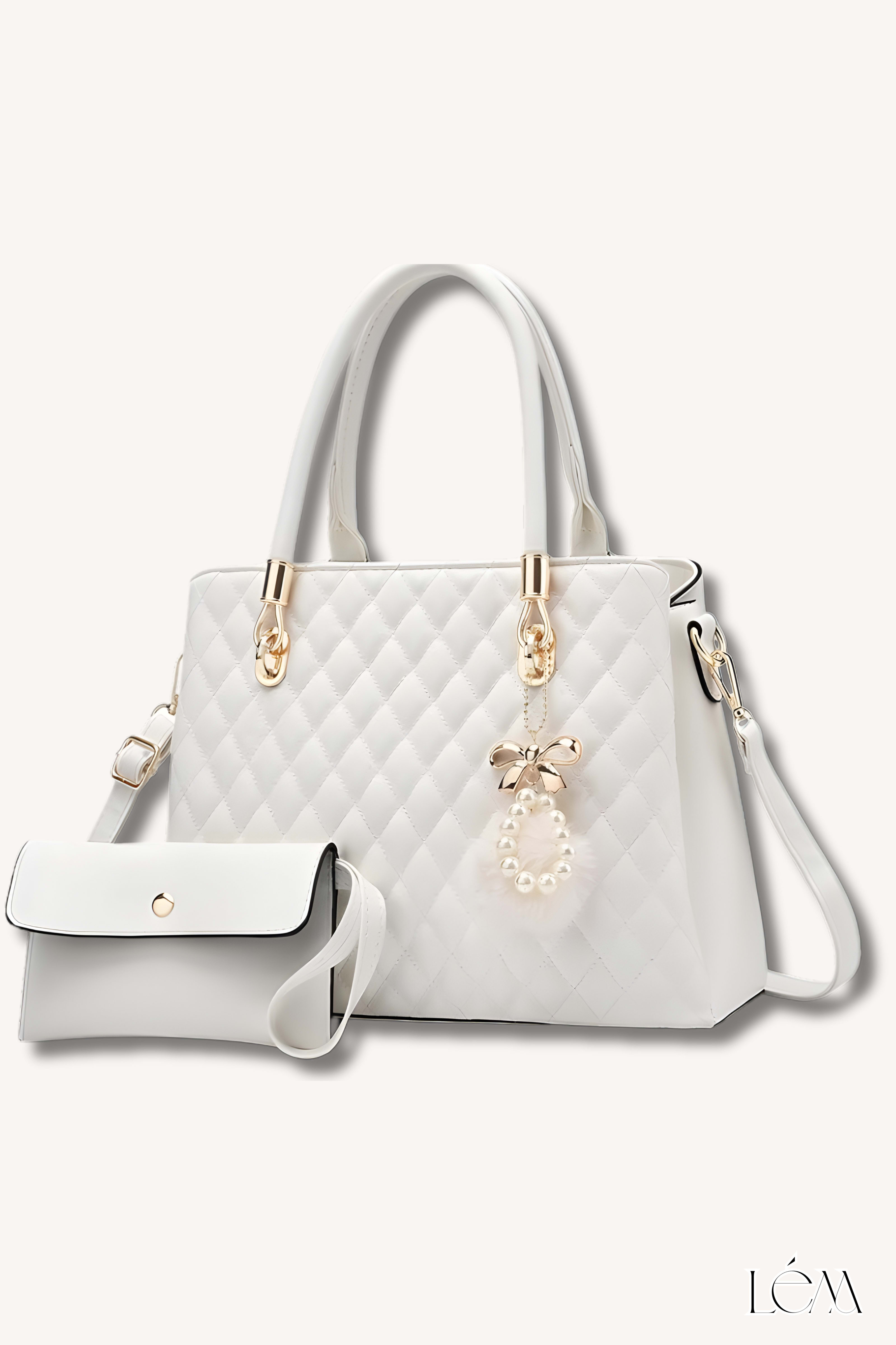 Close-up of quilted white handbag with gold hardware and charm detail