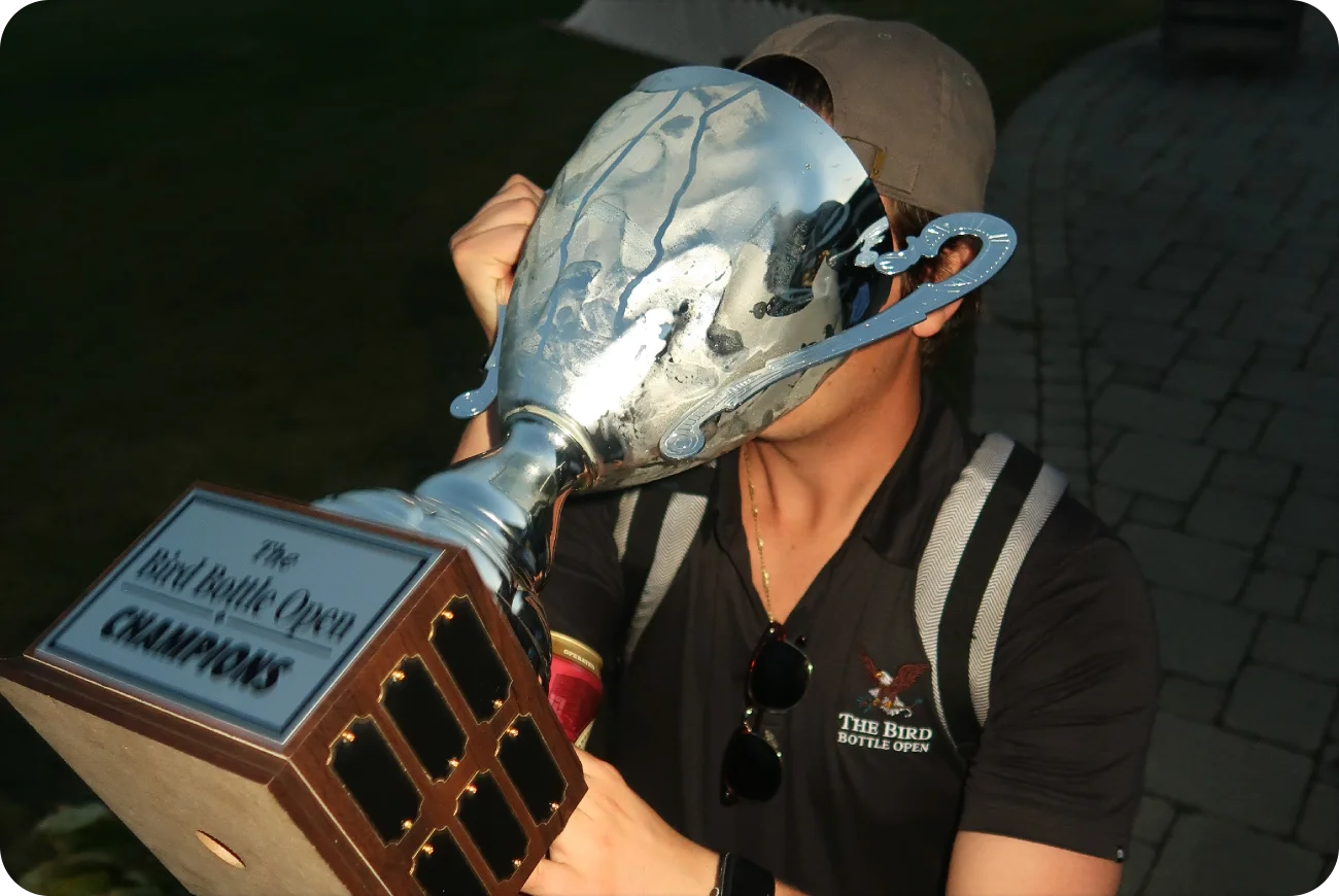 Winner drinking from the Bird Bottle Open Champions trophy