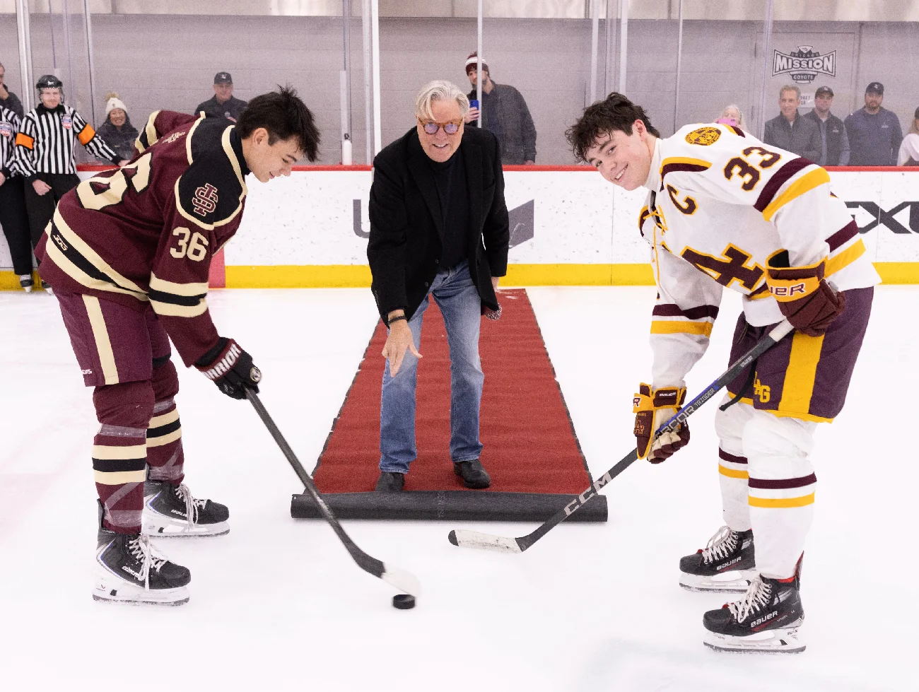 Ceremonial puck drop between two hockey players at the Keenan Casey Tribute Game
