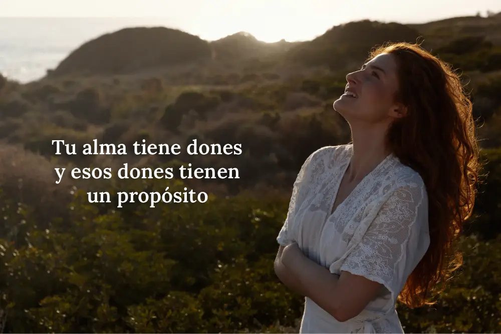 Mujer vestida de blanco mirando al cielo en un entorno natural, simbolizando la conexión con el alma y el descubrimiento de los dones que tienen un propósito en la vida