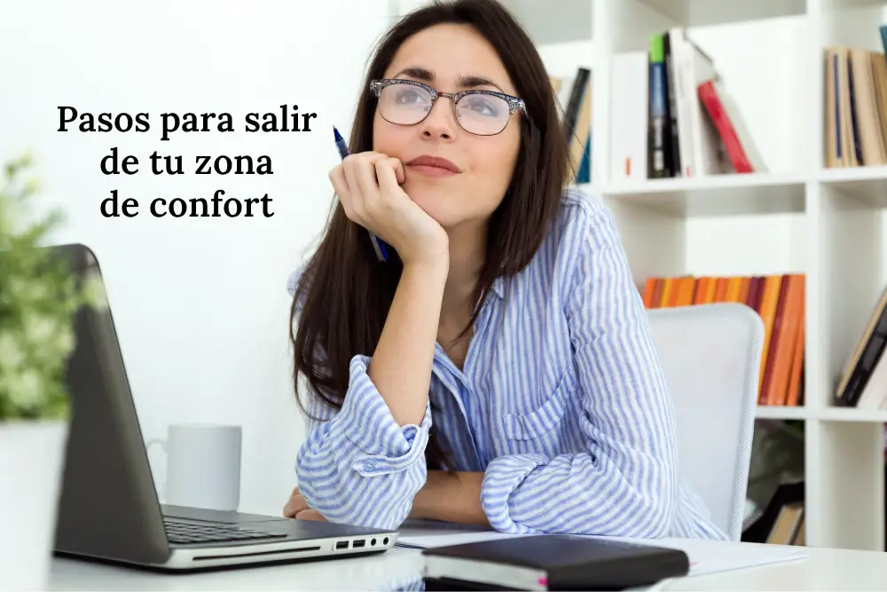 Mujer sentada en una oficina mirando el horizonte, reflexionando sobre su crecimiento personal y los pasos para salir de la zona de confort