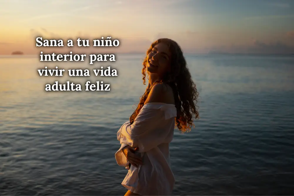 Mujer con el cabello suelto al atardecer en el mar, simbolizando libertad, introspección y el proceso de sanar el niño interior
