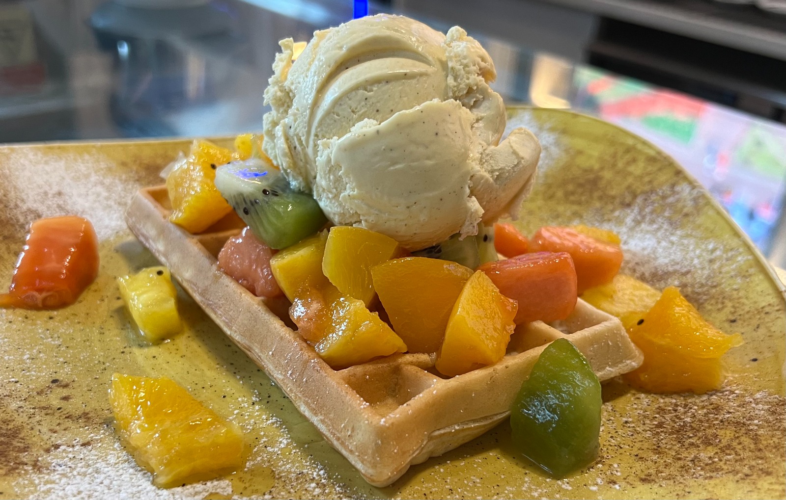 WAFFLE COM UMA BOLA DE GELADO, COBERTURA, FRUTA DA ÉPOCA
