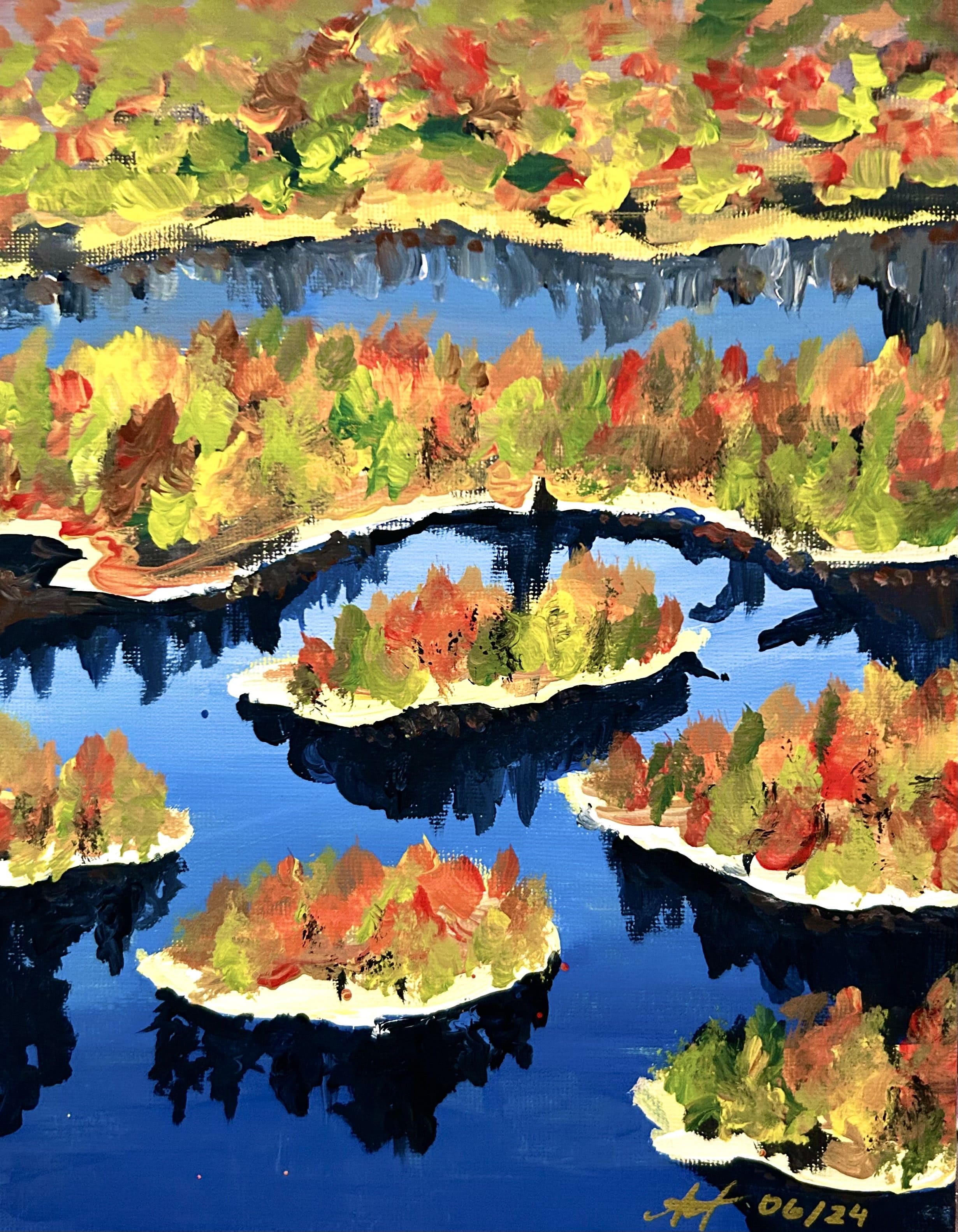 Between lakes, lay islands full of autumn trees and foliage that glow fiery and bright in the midst of calm, blue waters.