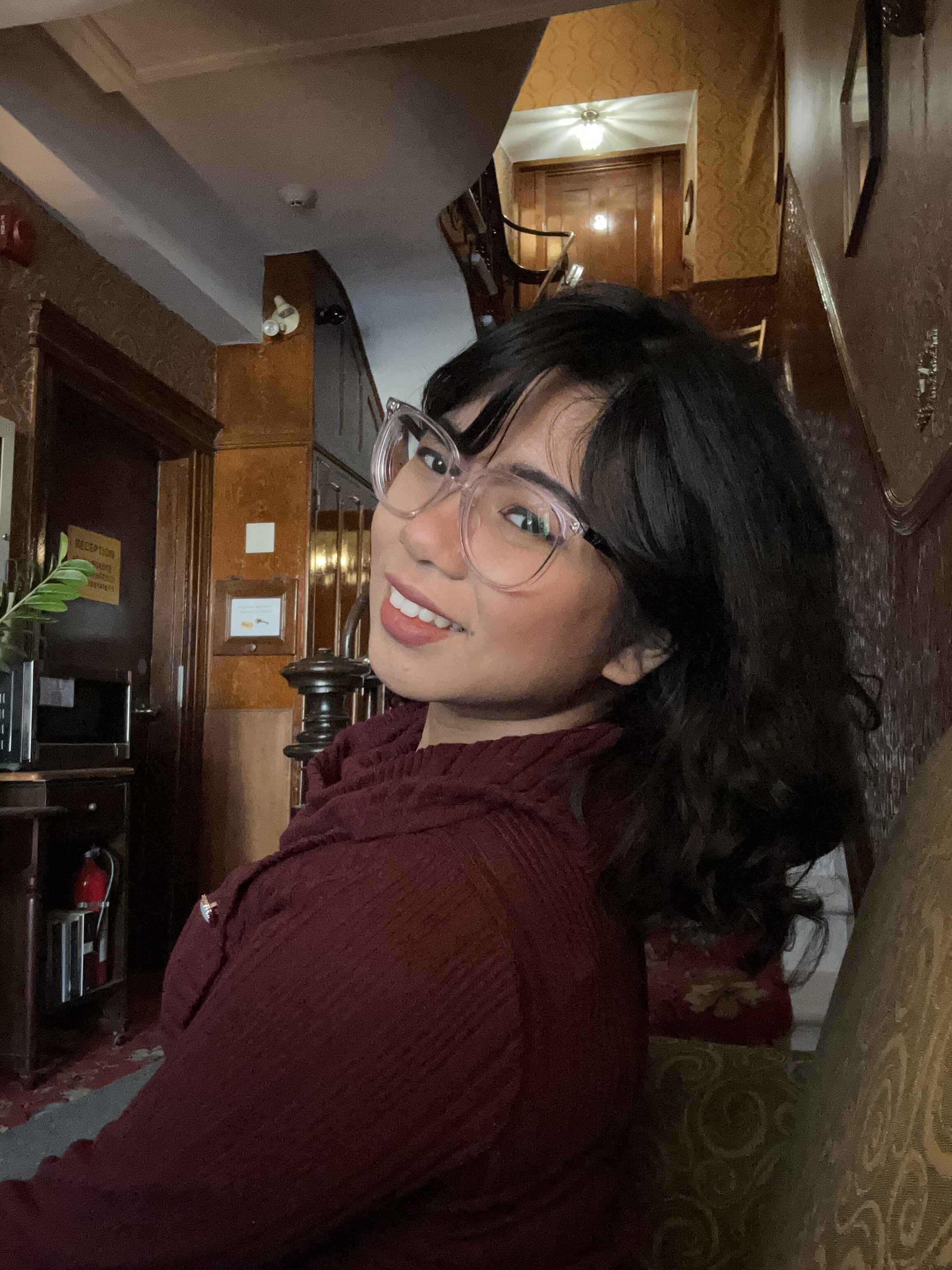 Andrea's artist portrait features a black haired woman with tan skin and burgundy sweater