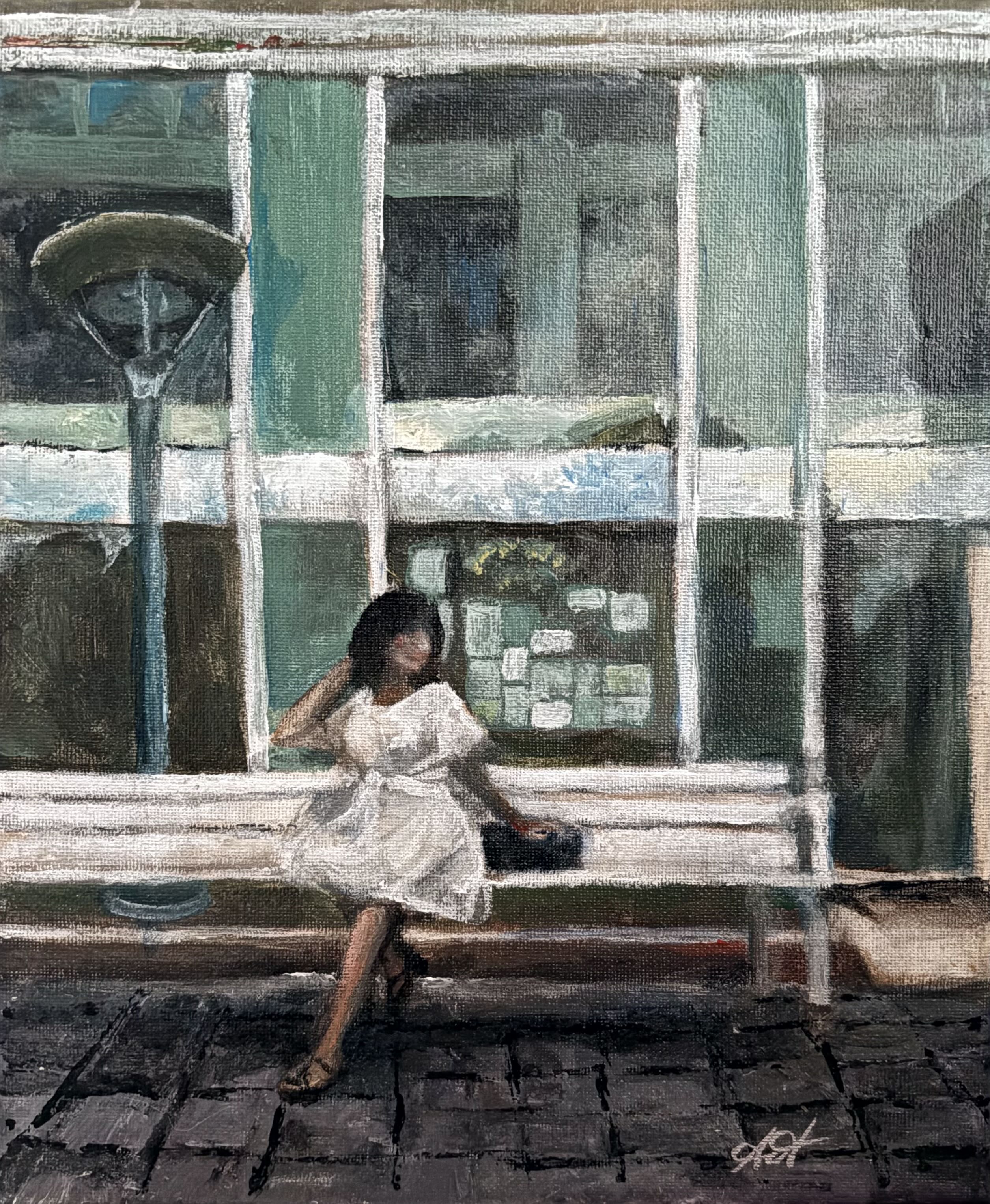 A brown-skinned lady in white dress and black sandals perches on a white picket bench, while a glass facility behind reflects the ways of the city.