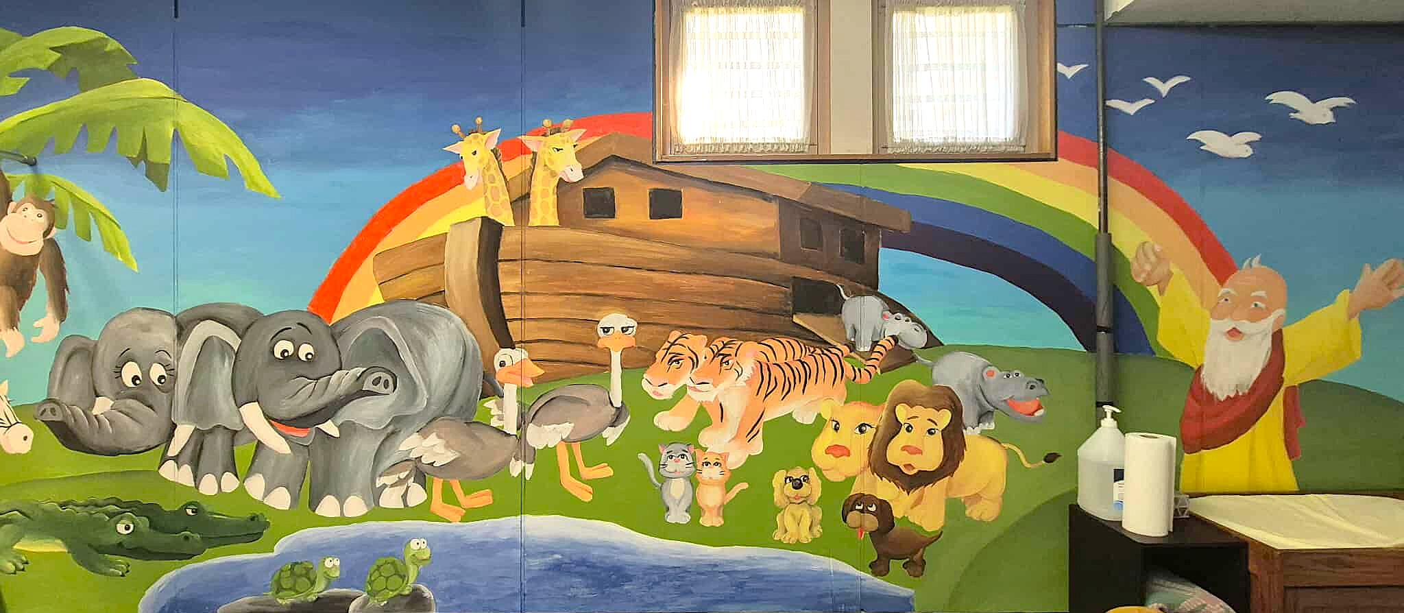 Collaborative mural done on a wall in the BBC Nursery featuring Noah's Ark.