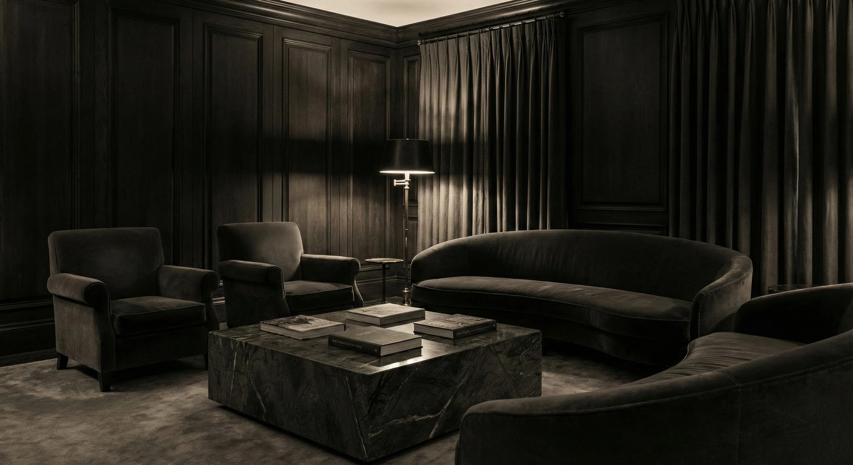 An intimate, sophisticated sitting room steeped in shadow. Rich dark wood paneling and velvet curved sofas surround a heavy dark marble coffee table, with a solitary floor lamp providing the only warm light in the space
