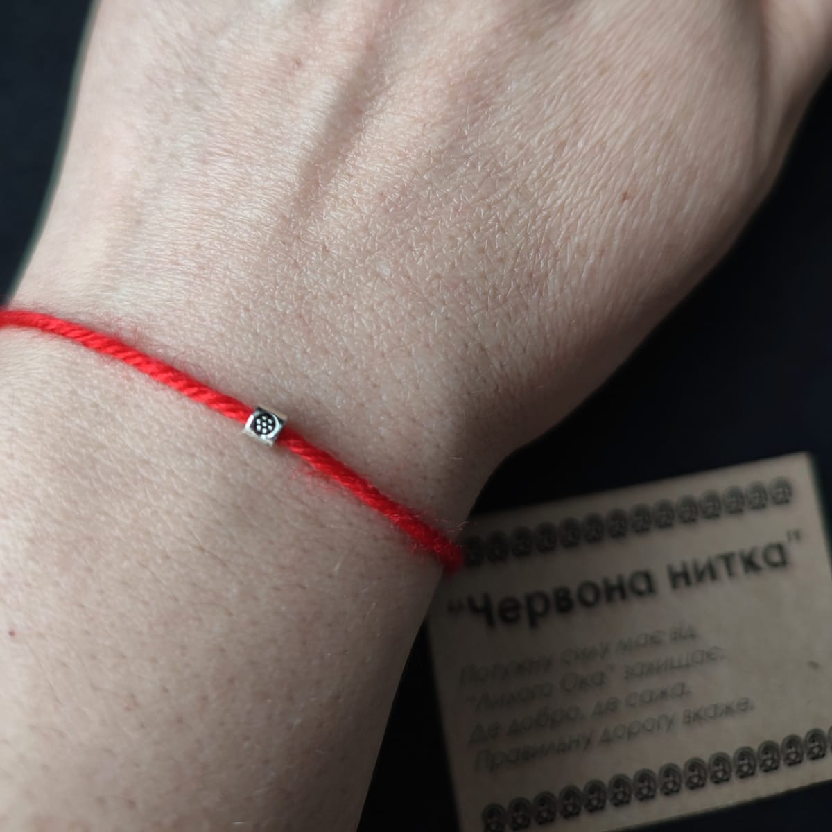 Червона ниточка на руку з бусинкою, символічний оберіг з вкладишем