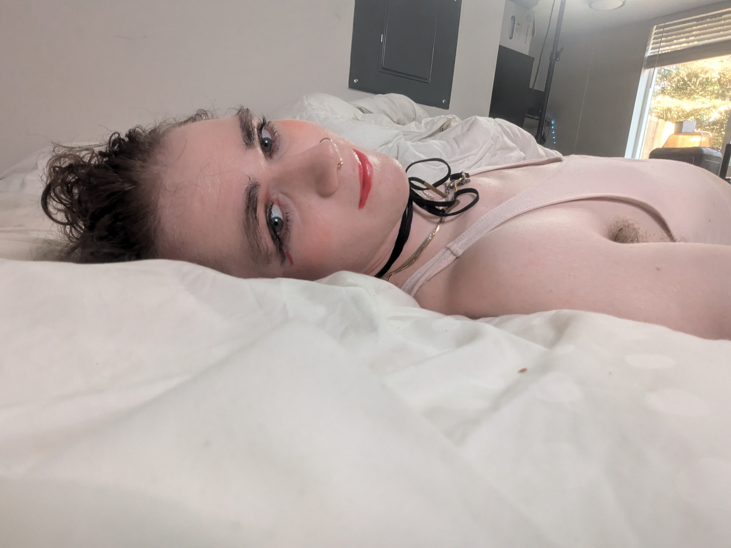 A woman laying in bed with a white blanket.