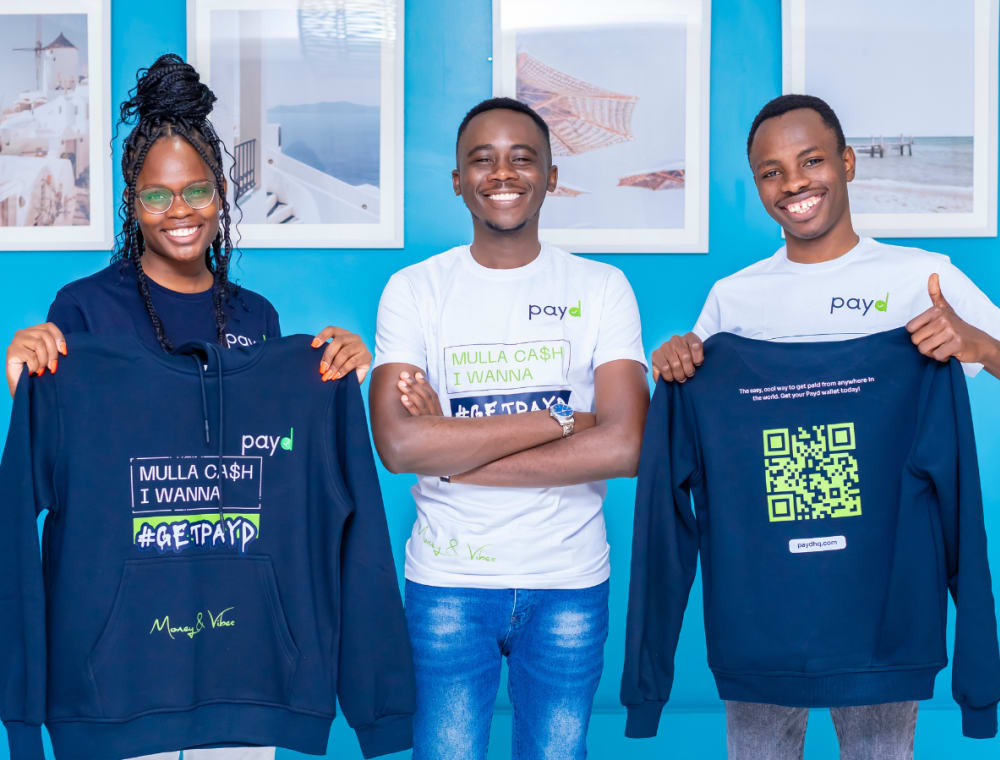 Members of the Payd community holding Payd hoodies