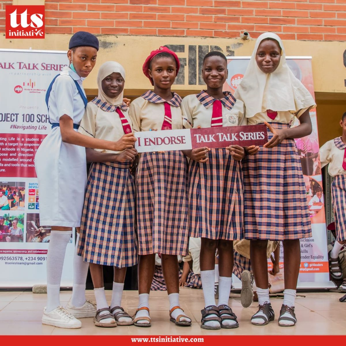 Five secondary school students holding Talk Talk Series signs at a 100 Schools event