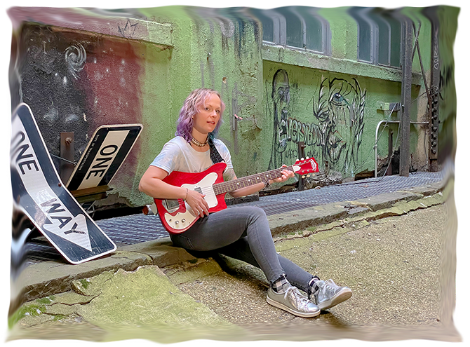 portrait of Elyza seated with guitar