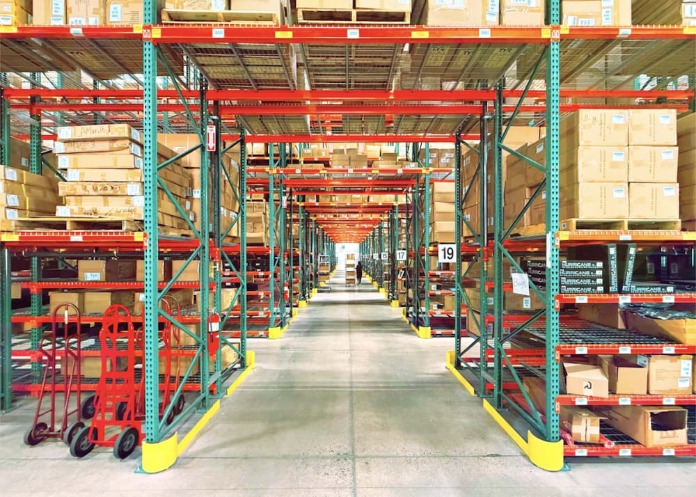Warehouse shelves stocked with boxes representing footwear import inventory India 2026