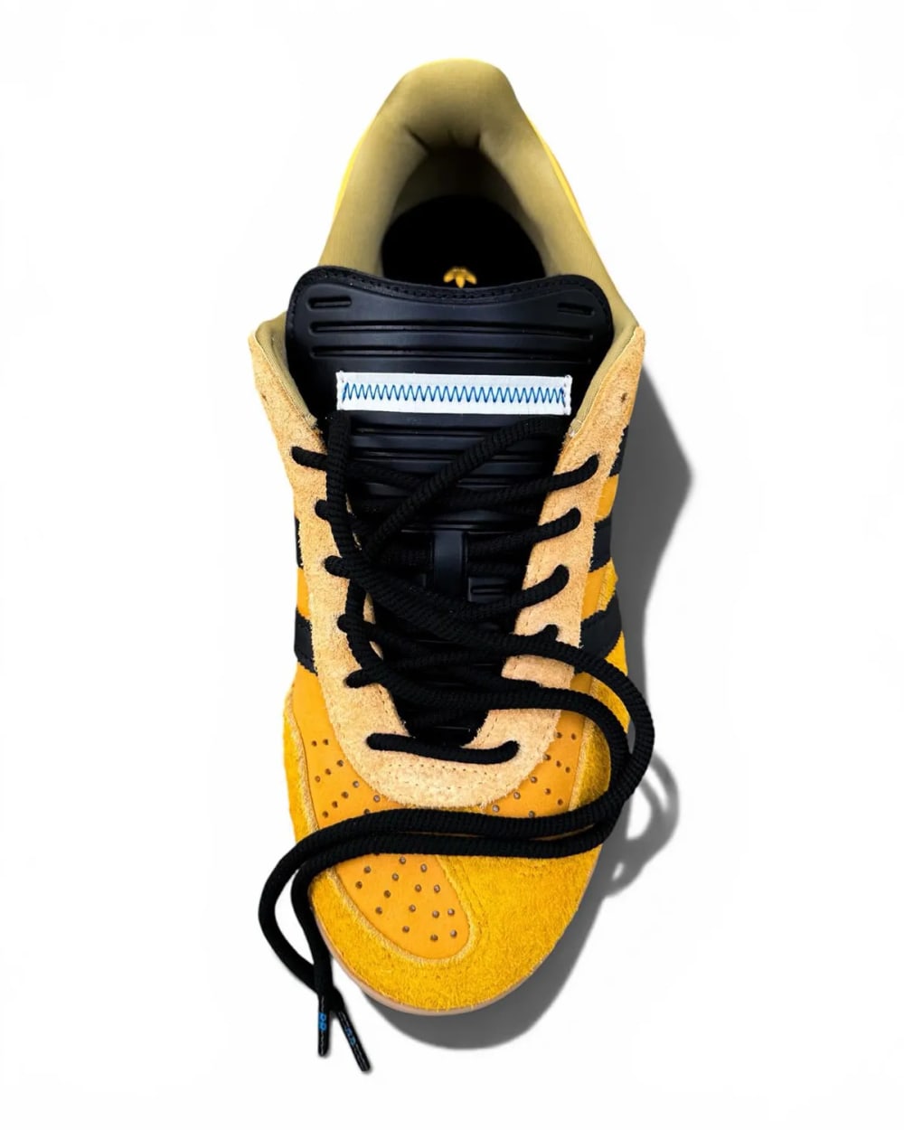 Top-down view of the Bad Bunny adidas Gazelle Indoor Solar Gold showing black laces, black tongue layer and suede toe overlay