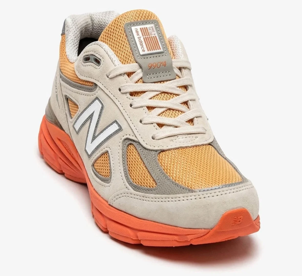 New Balance 990v4 Made in USA Moonbeam Tangerine Heat U990MO4 lateral view showing orange midsole and suede overlays 2026