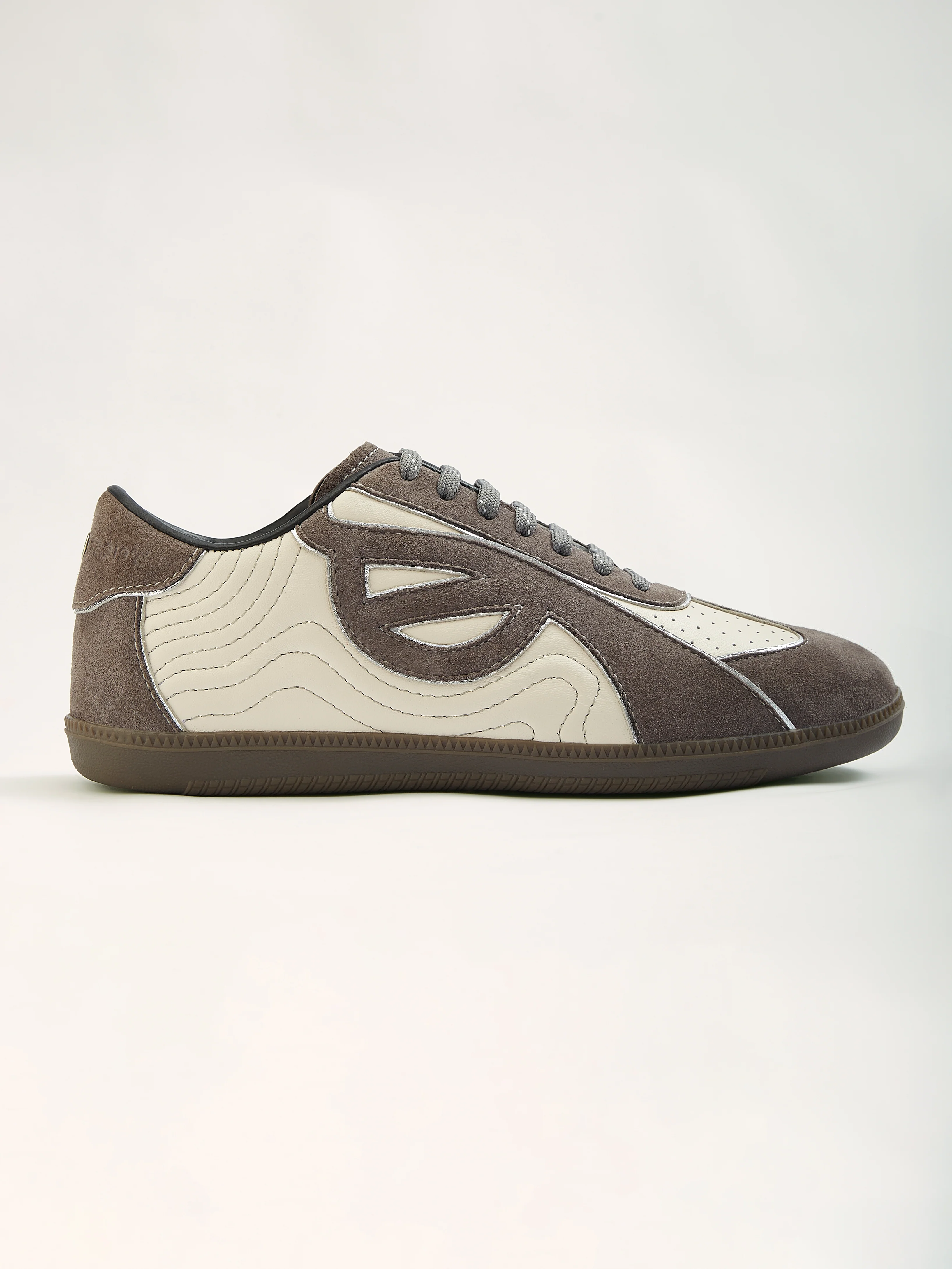 Grey and cream leather sneaker with wave-stitched textile panel, Indian artisan sneaker design 2026