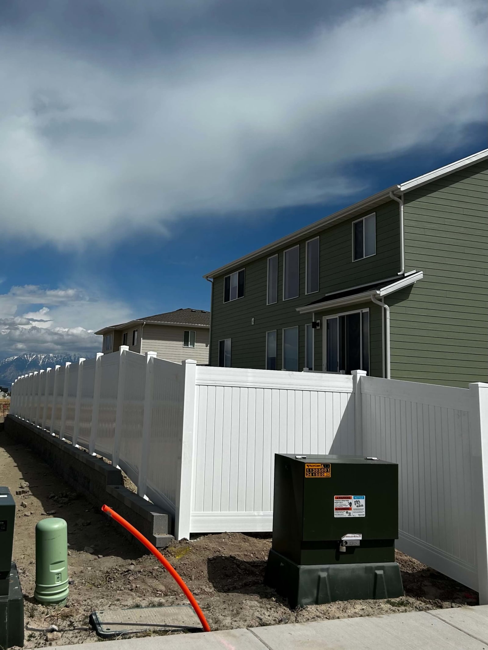 White privacy fence installed alongside a residential property