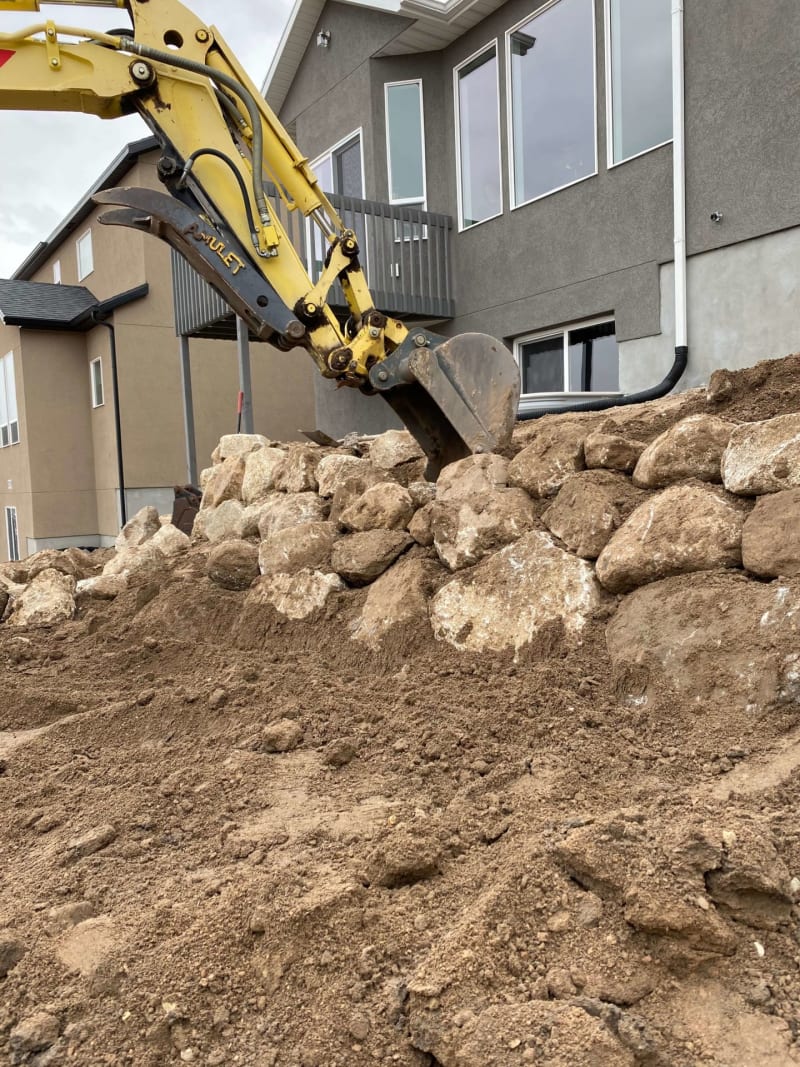 Excavation and boulder retaining-wall construction next to a home