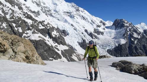 Aoraki Mount Cook Trek | A stunning 2 day trek amongst New Zealand's highest mountains - Trekker on Ball Ridge in front of Caroline Face 1