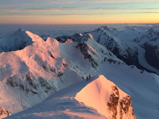 New Zealand Alpine Climbing, Mountaineering Instruction & Guided Ascents - Guided Alpine Ascents in New Zealand - Aoraki Mount Cook - A breathtaking aerial view of snow-capped mountain peaks bathed in the warm glow of the setting sun, creating a stunning contrast against the cool, blue hues of the sky. -  1