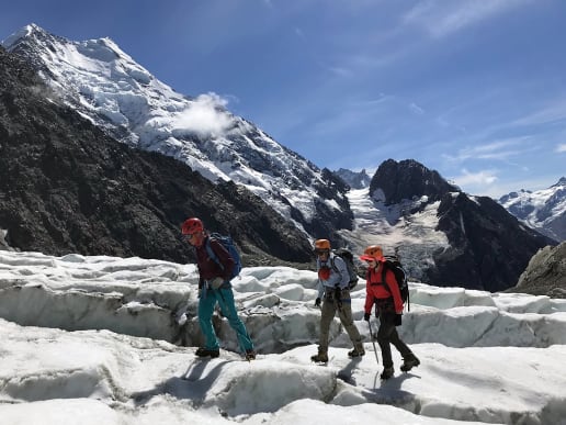 About - Preparing for your Mountain Adventure - Routes to and from Caroline Hut and Ball Ridge - Crossing the Ball Glacier in late summer conditions with exposed crevasses and hard ice - Hikers on Ball Glacier near Ball Pass with Aoraki Mount Cook in the background 10
